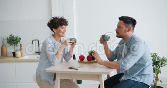丈夫和妻子在家中的餐桌上喝茶聊天视频的预览图