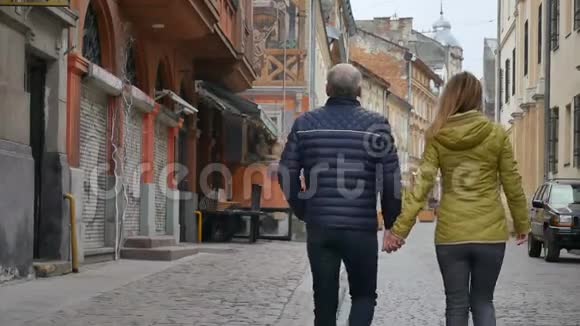 早春或秋季在古城户外散步的具有年龄差异的幸福浪漫情侣画像视频的预览图