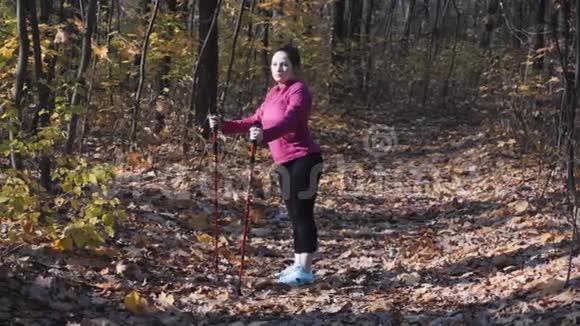 在城市秋季公园训练前用北欧步行杆进行伸展练习减肥概念视频的预览图