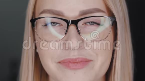 戴着金发眼镜白皙的皮肤和丰满的嘴唇看镜头的年轻商务女性的画像视频的预览图