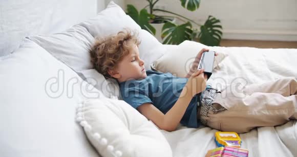 小孩看动画片躺在床上独自在家放松视频的预览图