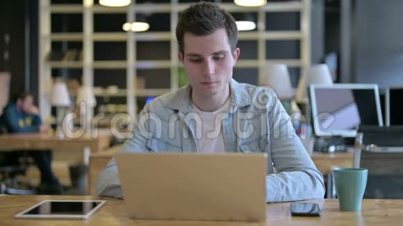 现代办公室使用笔记本电脑的年轻男性设计师视频的预览图
