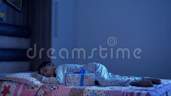 一个可爱的小男孩清晨醒来打开圣诞礼物圣诞老人视频的预览图
