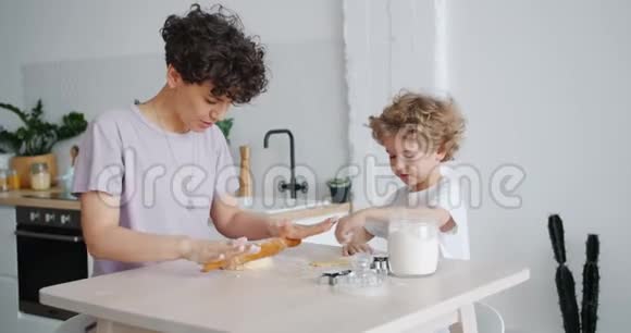 快乐的女孩和小儿子在厨房里做饼干视频的预览图