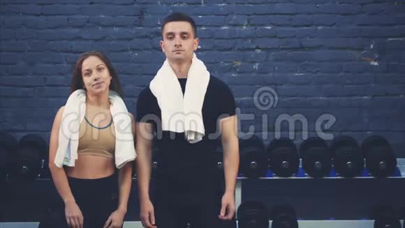 一个穿黑色T恤的运动小男孩和一个女孩站在健身房里有运动身体的人在这期间他们视频的预览图