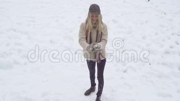 冬天的女人玩雪球金发美女做雪球冬天与雪的游戏视频的预览图