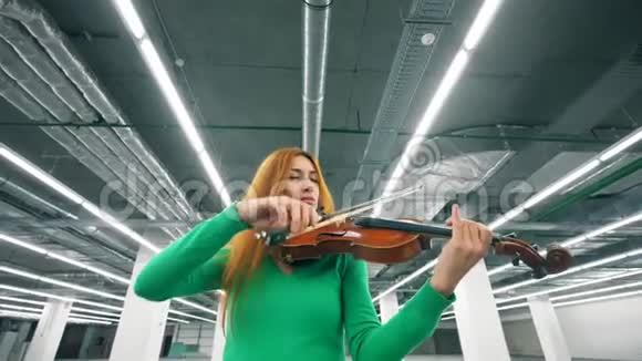 专注的女人正在大厅里拉小提琴视频的预览图