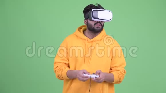 年轻的超重留胡子的印度男人在玩游戏使用虚拟现实耳机视频的预览图