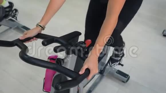 健身妇女在健身房的自行车课上旋转静态自行车肖像运动女性呼吸同时进行有氧训练视频的预览图