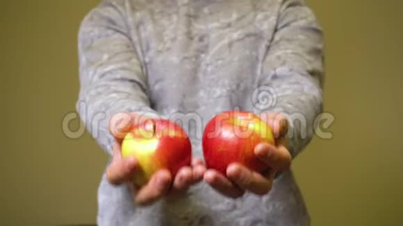 男人手里拿着两个红苹果视频的预览图