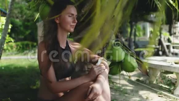 高加索女人坐在椰子树下视频的预览图
