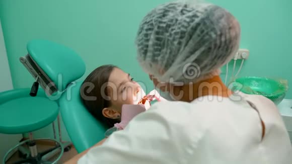 女牙医检查女孩的口腔视频的预览图