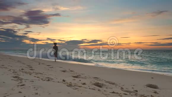 年轻女子在海边奔跑日落视频的预览图
