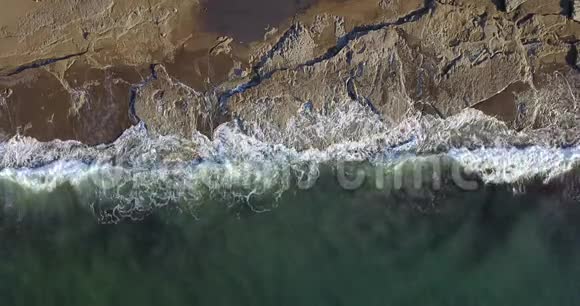 石质海岸地段的鸟瞰图可看到海浪和浪花视频的预览图