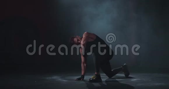 拍健美的男人在镜头前的黑色摄影棚里展示他的肌肉他穿着职业运动服视频的预览图