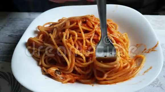 一名白种人男性在午餐时用钢叉卷起意大利面条和番茄酱意大利食品和烹饪传统视频的预览图