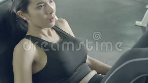 美丽的亚洲年轻女子运动训练用压腿机在健身房锻炼身体视频的预览图