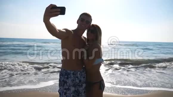 年轻的微笑夫妇在海景背景下拍照海洋海岸的快乐旅行情侣摄影视频的预览图
