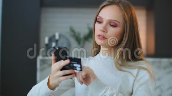 一个女人拿着一张信用卡和一部智能手机按在触摸屏上网上购物过圣诞节支付视频的预览图