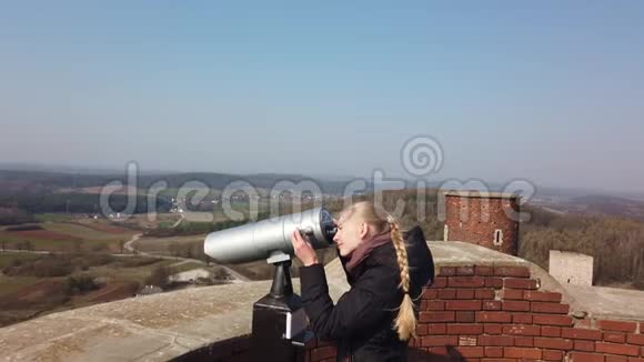 利用塔式光学观察器观察古堡附近山谷的迷人女性游客视频的预览图