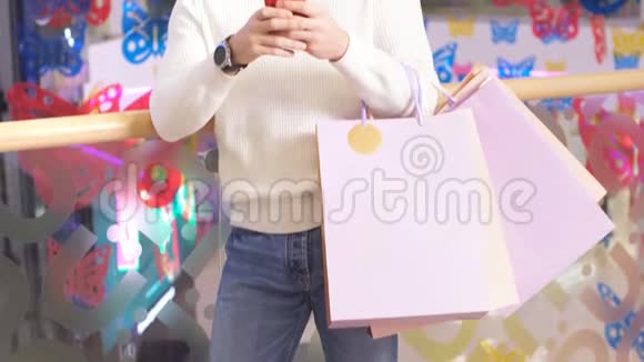 购物中心的快乐男人手里拿着圣诞礼物用智能手机视频的预览图