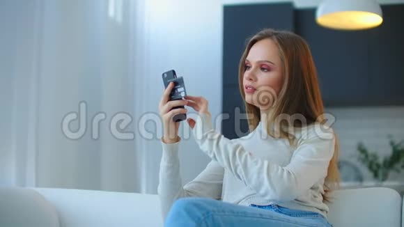 设置应用程序来支付使用智能手机购买的费用年轻漂亮的女人从舒适的家购物视频的预览图