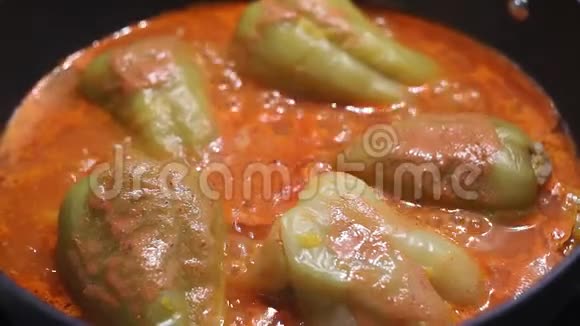 装满碎肉的五颜六色的辣椒在炉子上的平底锅里炖在厨房附近烹饪美味的食物视频的预览图