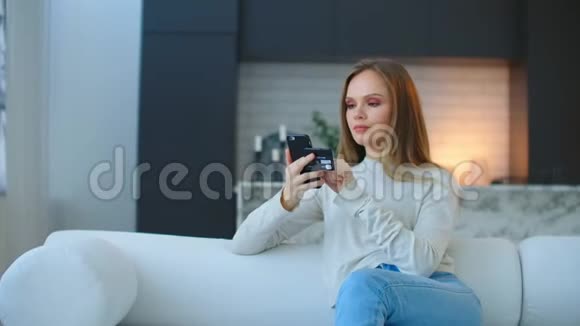 一个快乐微笑的女人拿着一部智能手机为送比萨饼买单在网上购买健康素食产品视频的预览图