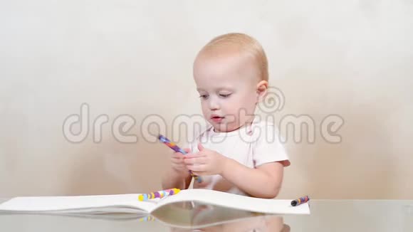 一个小女孩把蜡笔涂在相册上一张卷到地板上视频的预览图