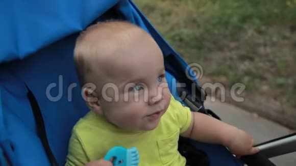 好奇的小男孩坐在户外的婴儿车里视频的预览图