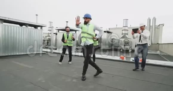 一个戴着眼镜留着胡子的建筑高手在他的工人朋友面前跳着现代舞也都是视频的预览图