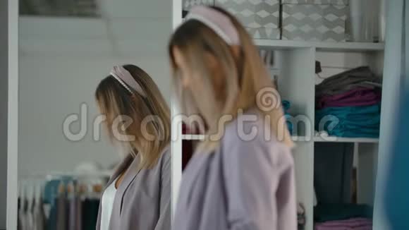 时髦的女人在商店里靠近镜子旋转视频的预览图