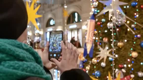 白人妇女在商场拍圣诞树的照片关门视频的预览图