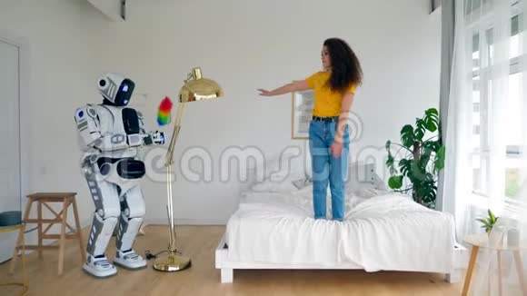 机器人正在除尘女士正在床上跳舞智能家居概念视频的预览图