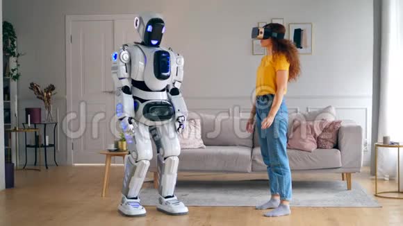 像人一样的机器人正在触摸一位戴着VR眼镜的女士的手智能家居概念视频的预览图