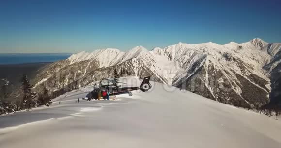 Actionsportlers被直升机降落在山顶上太阳在蓝天上闪闪发光视频的预览图