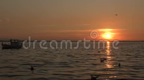 漂浮在海上夕阳下的木制渔船视频的预览图