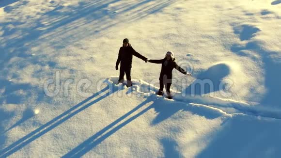 快乐的年轻家庭正在雪地里玩得很开心他们高兴地掉进了雪里男孩和女孩快乐爱视频的预览图