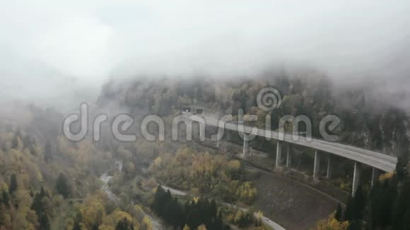 山村在山谷和铁路桥梁景观带村庄和风景如画的山谷的鸟瞰图视频的预览图