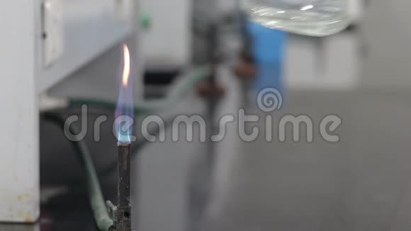 在化学实验室用蓝色燃烧器火焰加热锥形烧瓶中的无色液体视频的预览图
