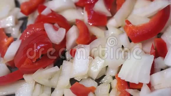 切好的洋葱红椒炒在菜油锅里在炽热的煎锅上烤视频的预览图