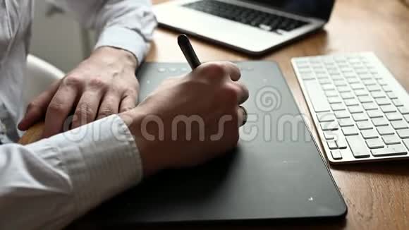 男人用数字笔和平板电脑画画设计师或摄影师使用钢笔平板电脑视频的预览图