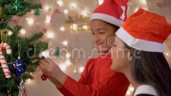 小女孩和妈妈一起装饰圣诞树视频的预览图