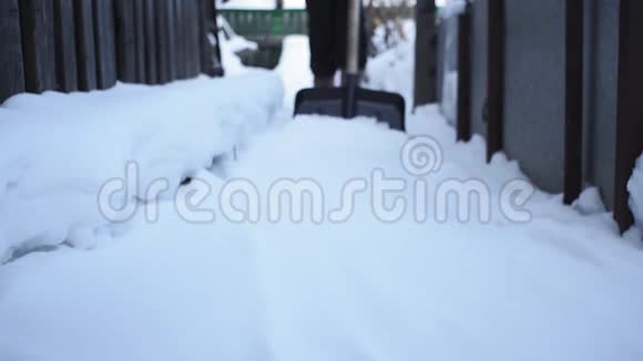 女人从人行道上铲雪快关门在家里铲雪冬季视频的预览图