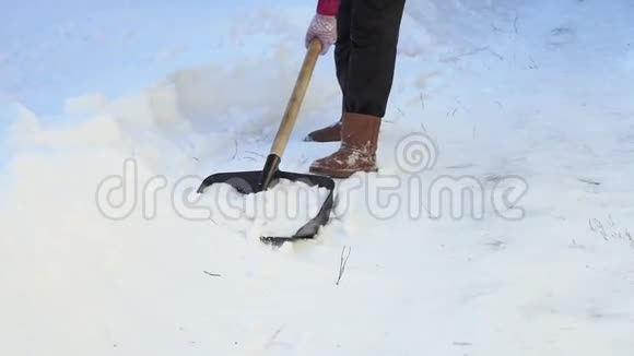 女人从人行道上铲雪快关门在家铲雪冬季视频的预览图