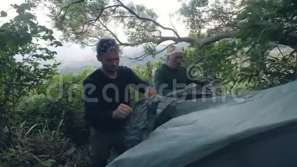 两名男子露营者在森林露营中搭建帐篷与与大自然融为一体视频的预览图