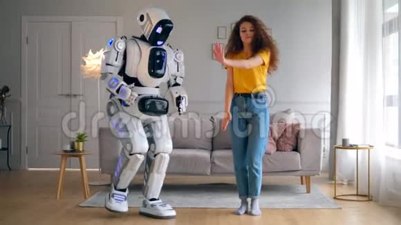 漂亮的女士和机器人在客厅里跳舞智能家居概念视频的预览图