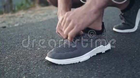 一名年轻的白人男子在跑步前把鞋系好站起来欣赏风景视频的预览图