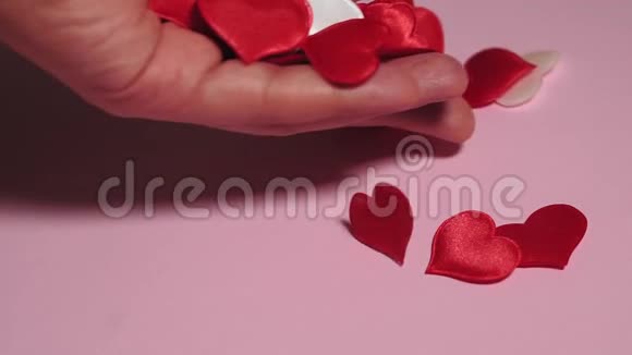 红心在粉红色的背景上手摆出红心爱情概念情人节视频的预览图