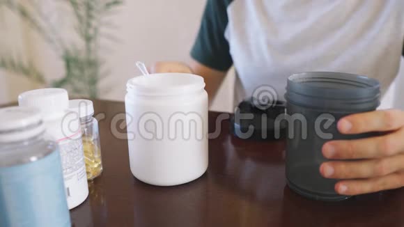 男人在餐桌上的摇床里做一种与水混合的饮食蛋白鸡尾酒视频的预览图
